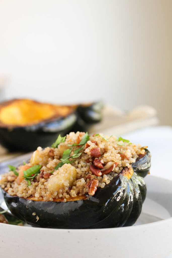 Easy Fall recipe ideas side view of acorn squash stuffed with quinoa apple mixture