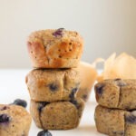 three blueberry muffins stacked on top of each other on a white background