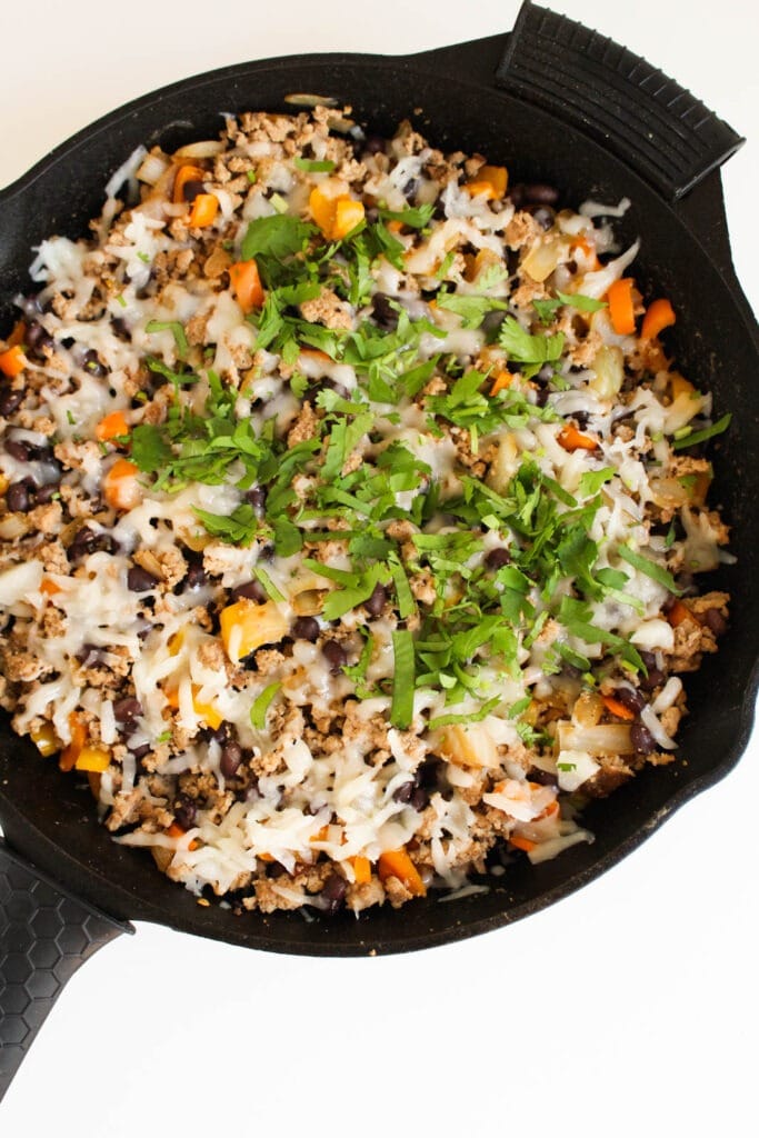 turkey taco skillet topped with cilantro in a cast iron skillet